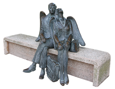A Statue Of A Man And Woman Sitting On A Bench