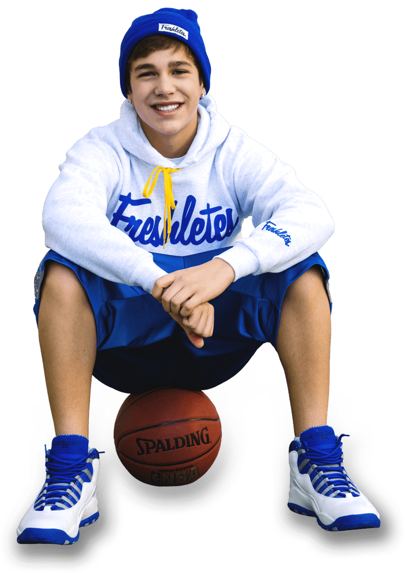 A Boy Sitting On A Basketball