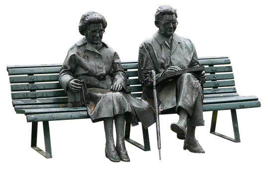 Statue Of A Man And Woman Sitting On A Bench