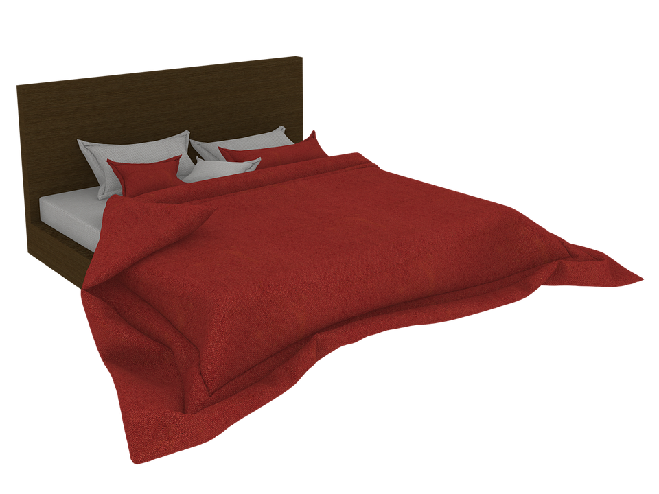 A Bed With Red Blanket And Pillows