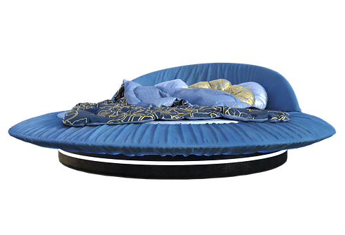 A Round Bed With A Blue Blanket And A Black Background