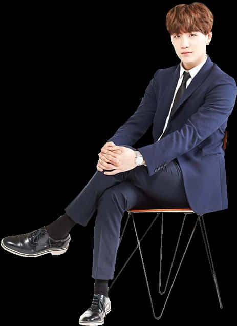 A Man In A Suit Sitting On A Chair