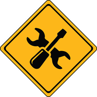 A Yellow Sign With A Screwdriver And Wrench
