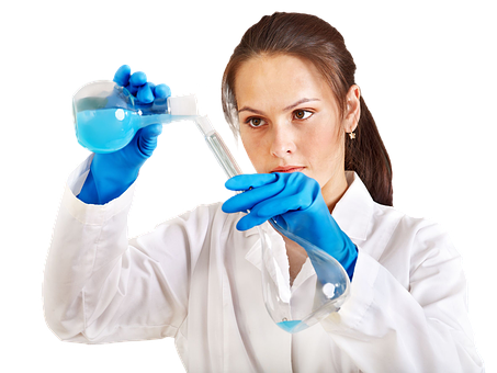 A Woman In A White Coat Pouring Liquid Into A Flask