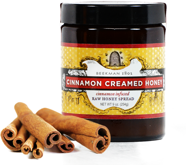 A Jar Of Honey Next To Cinnamon Sticks