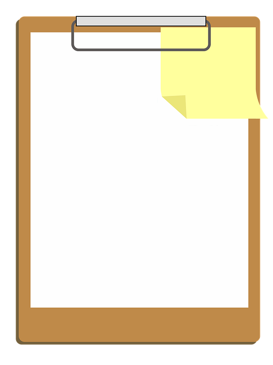 A Clipboard With A Yellow Sticky Note