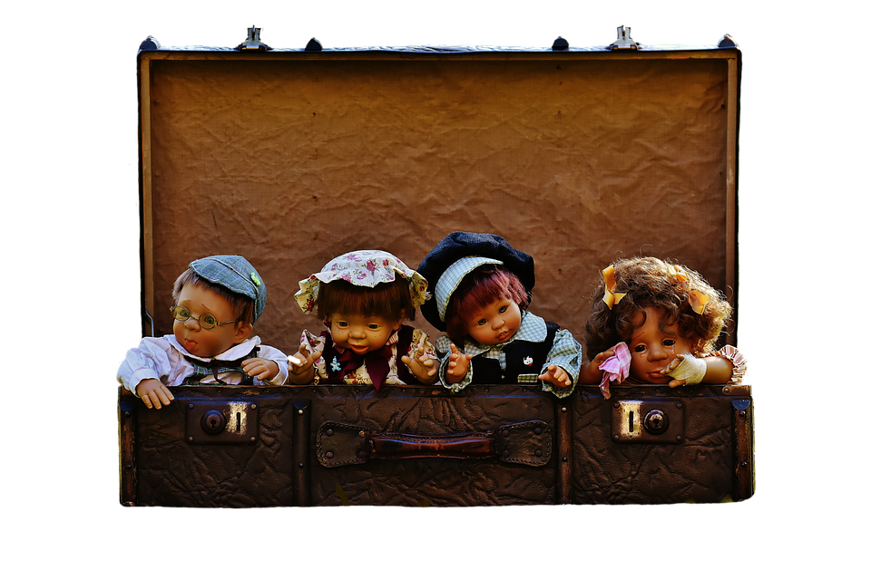 A Group Of Dolls In A Suitcase