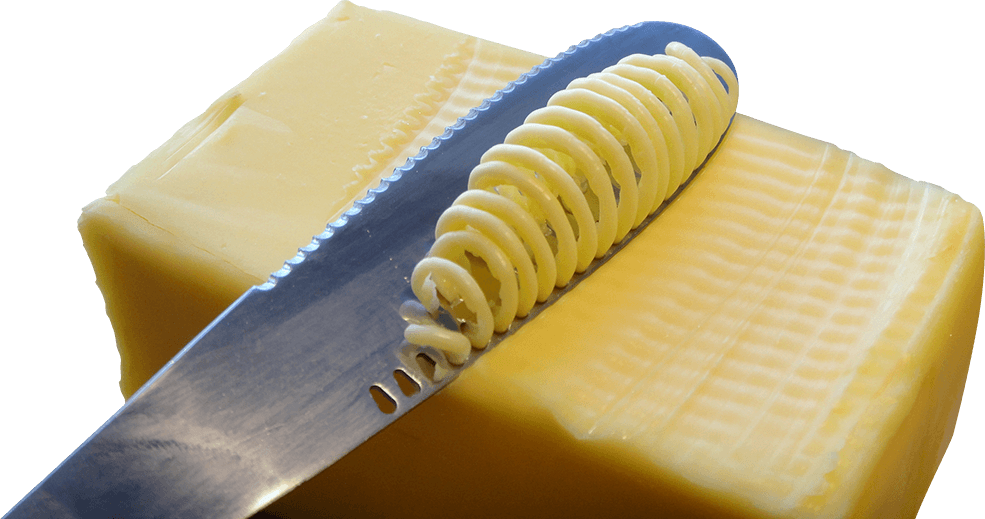 A Knife With Spirals Of Butter On A Block Of Cheese