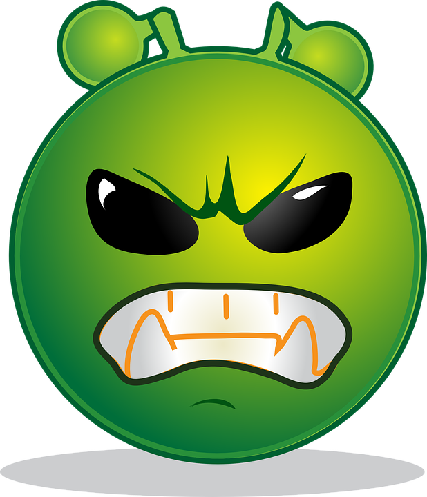 A Green Cartoon Face With Black Eyes And Teeth