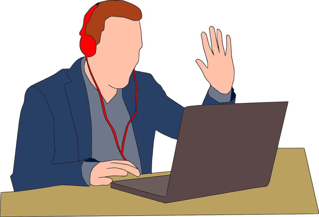 A Man Wearing Headphones And Using A Laptop