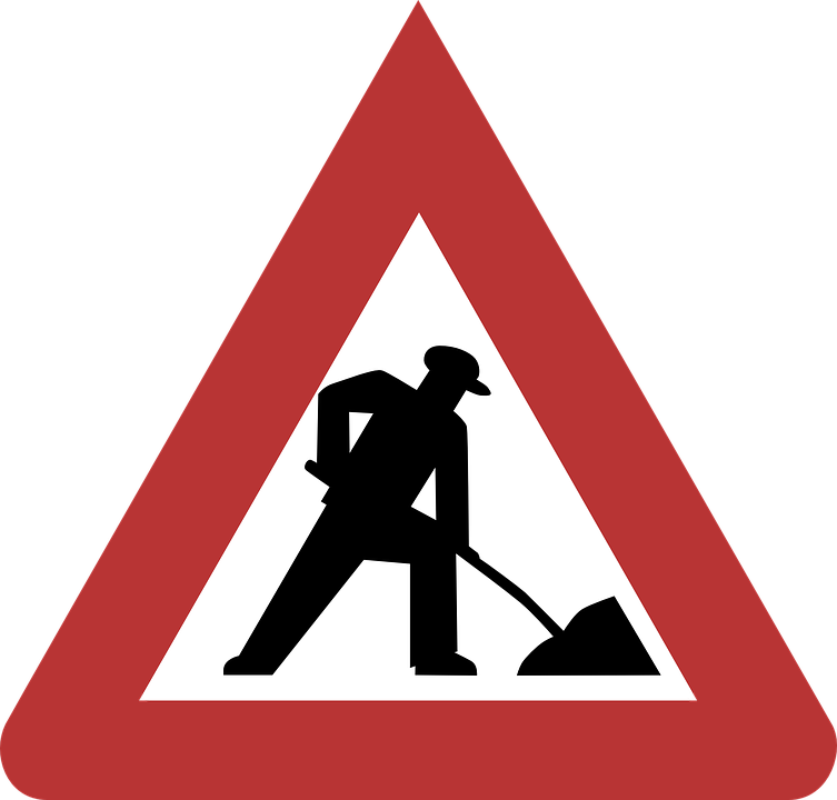 A Road Sign With A Man Digging A Hole