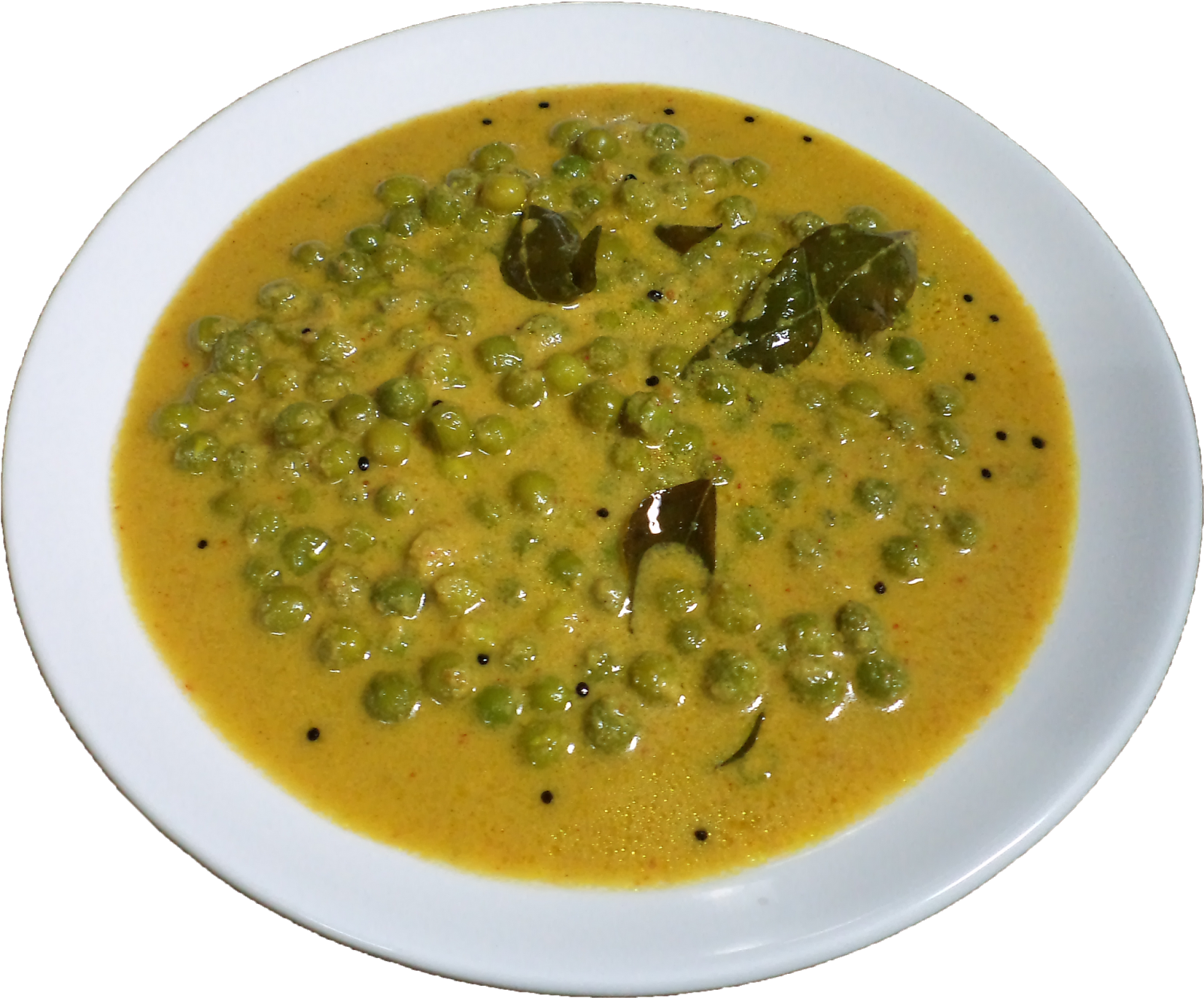 A Bowl Of Soup With Green Peas And Leaves