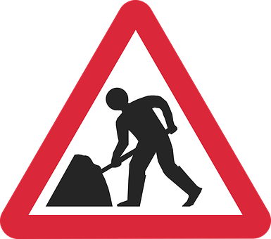 A Red Triangle Sign With A Man Digging A Rock