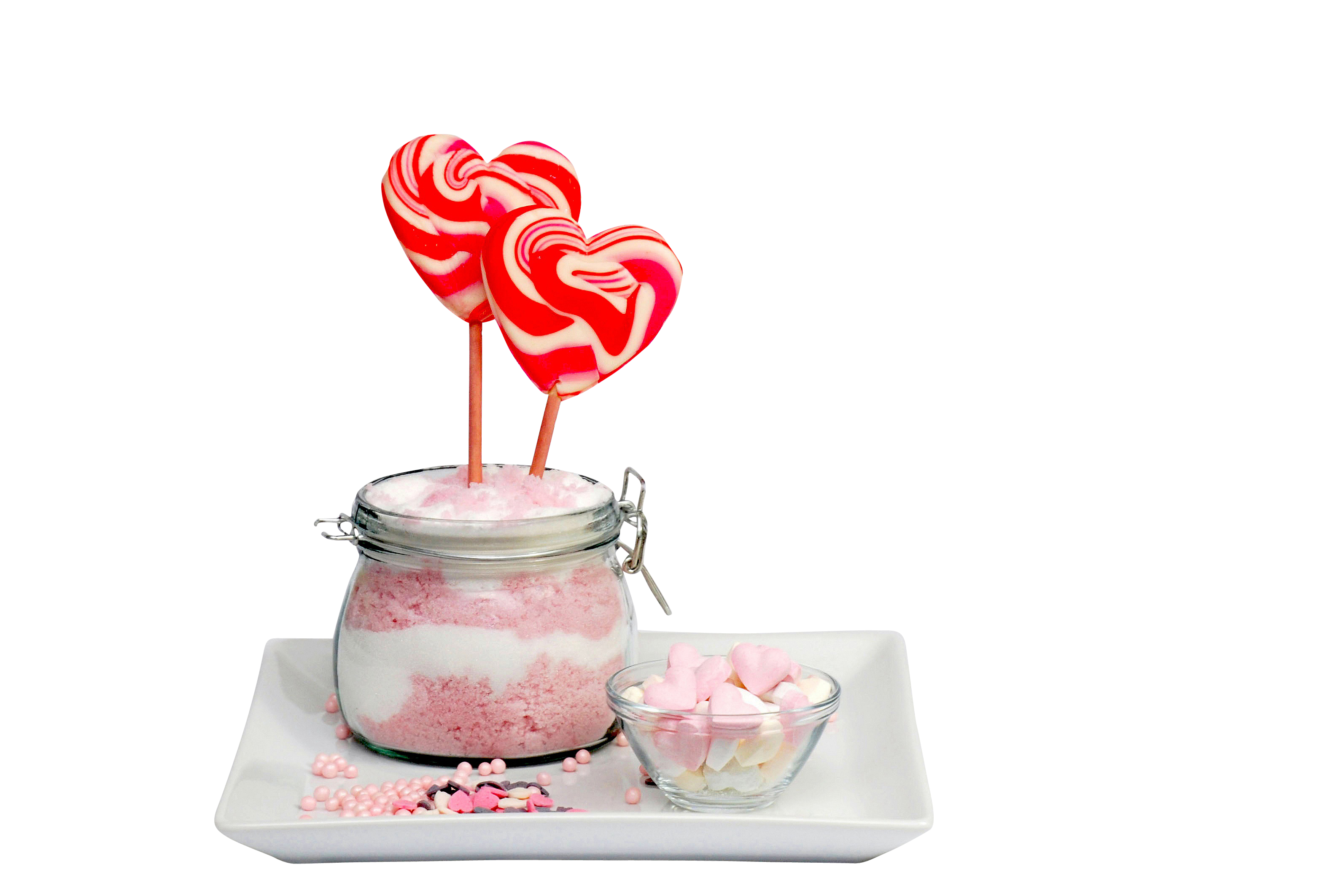 A Jar Of Pink And White Dessert With Two Lollipops On Sticks