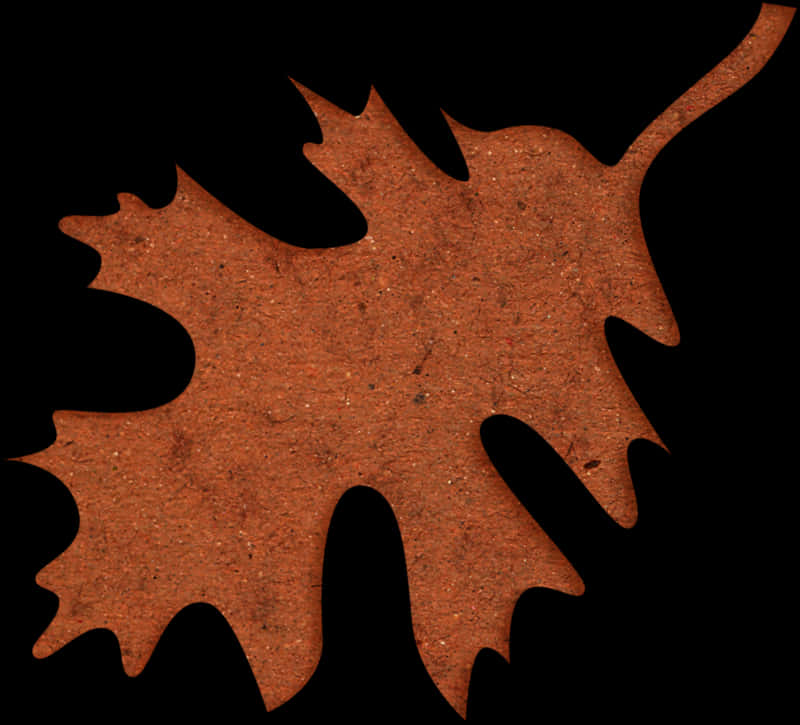 A Brown Leaf Cut Out Of A Black Background