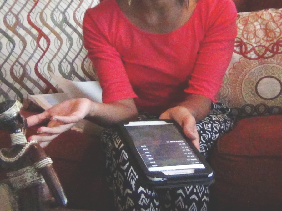 A Woman Sitting On A Couch Holding A Tablet