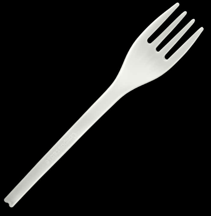 A White Plastic Fork On A Black Background