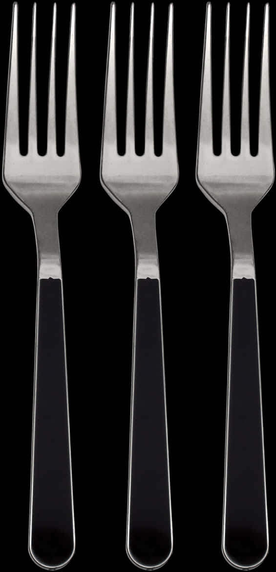 A Row Of Forks With Black Handles