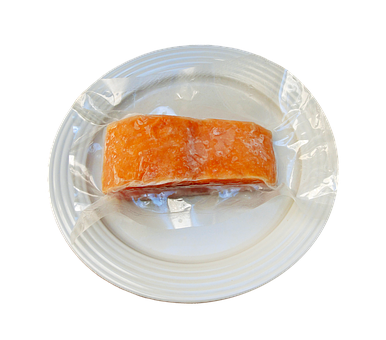 A Piece Of Food Wrapped In Plastic On A White Plate