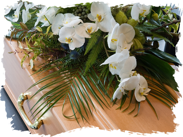 A Casket With White Flowers And Green Leaves