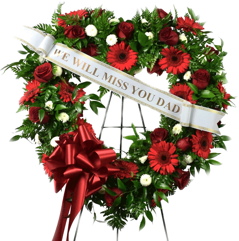 A Heart Shaped Wreath With Red Flowers And A White Ribbon