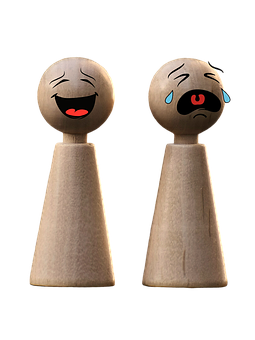 A Couple Of Wooden Pegs With Faces Drawn On Them