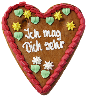 A Gingerbread Heart With White And Yellow Decorations