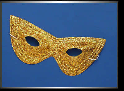A Gold Glittered Mask On A Blue Background
