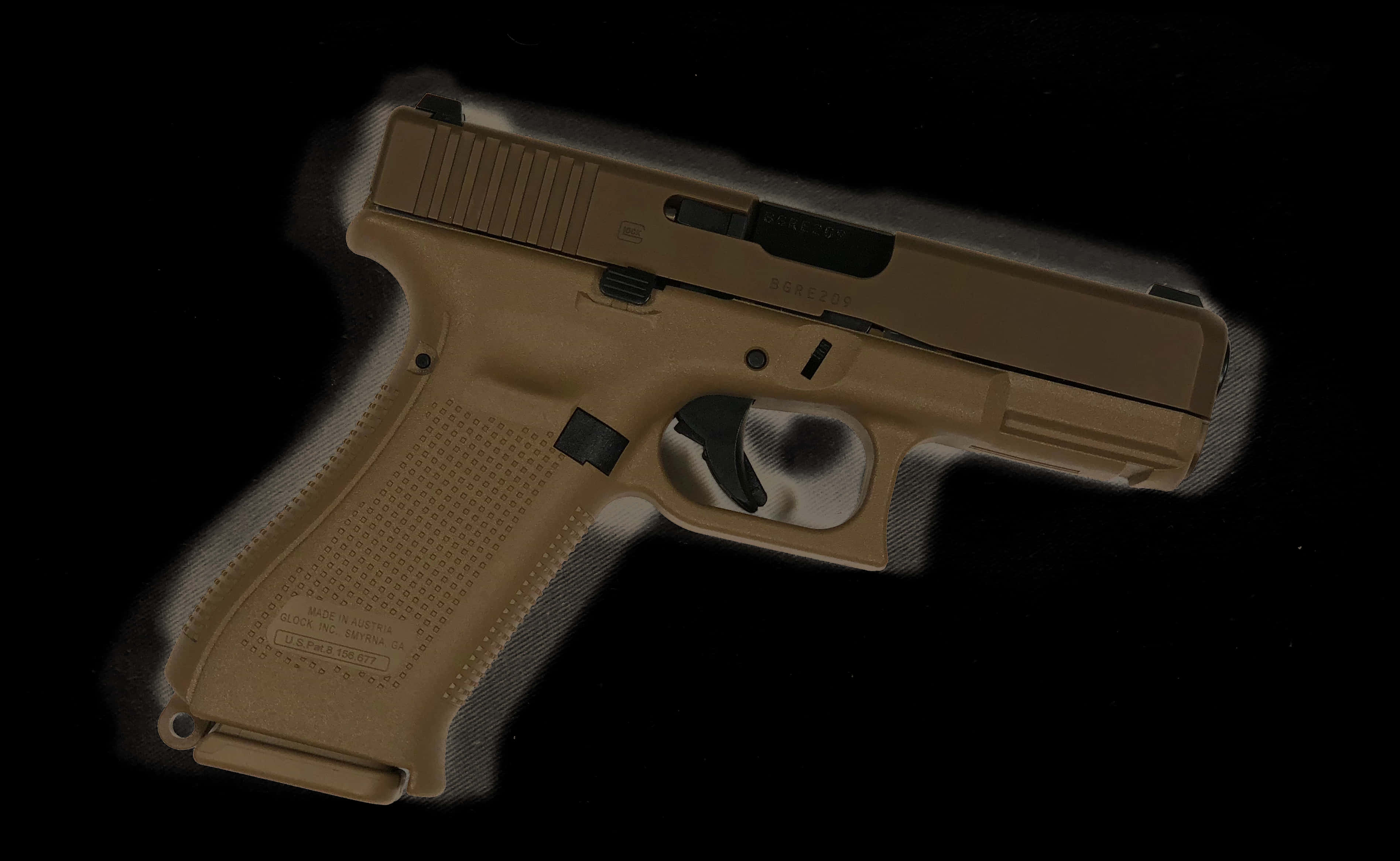 A Tan Handgun On A Black Background
