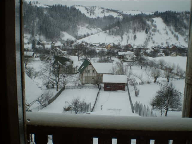 A Snowy Landscape With Houses And Trees