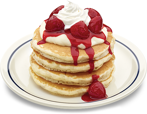 A Stack Of Pancakes With Whipped Cream And Strawberries