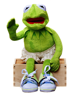 A Green Frog Puppet Sitting On A Wooden Box