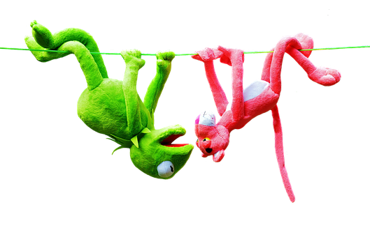 A Green And Pink Stuffed Animals From A Rope