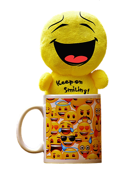 A Yellow Stuffed Animal With A Smiley Face On A Mug
