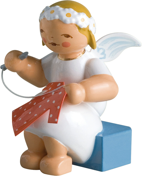A Ceramic Figurine Of A Angel Holding A Red And White Letter