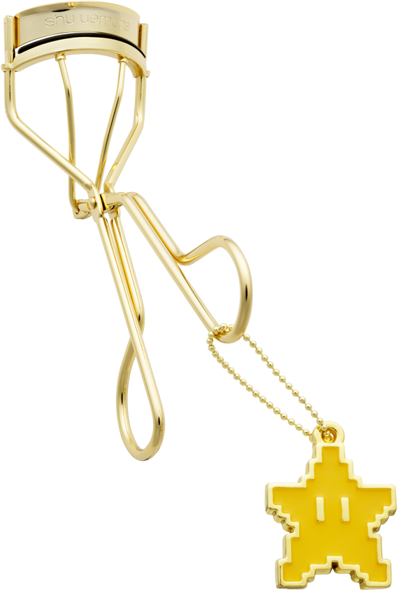 A Gold Eyelash Curler With A Cross Pendant