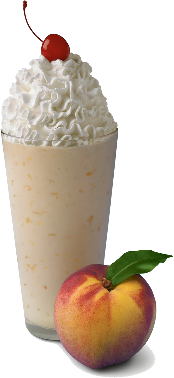 A Glass Of Milkshake With Whipped Cream And A Peach