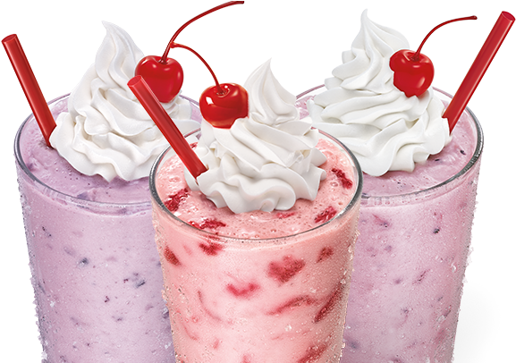 A Group Of Pink And Purple Milkshakes With Whipped Cream And Cherries