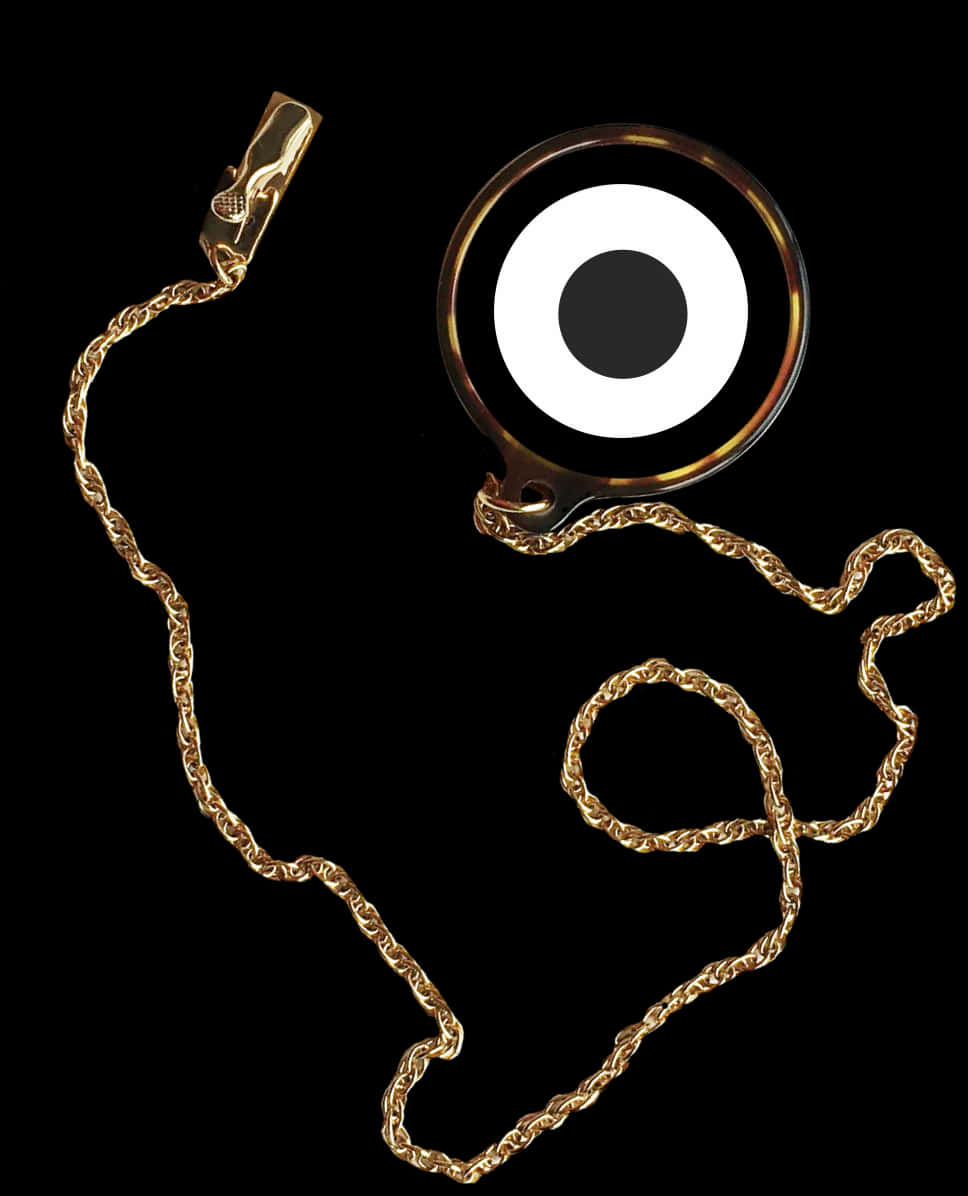 A Gold Chain With A Black Circle On It