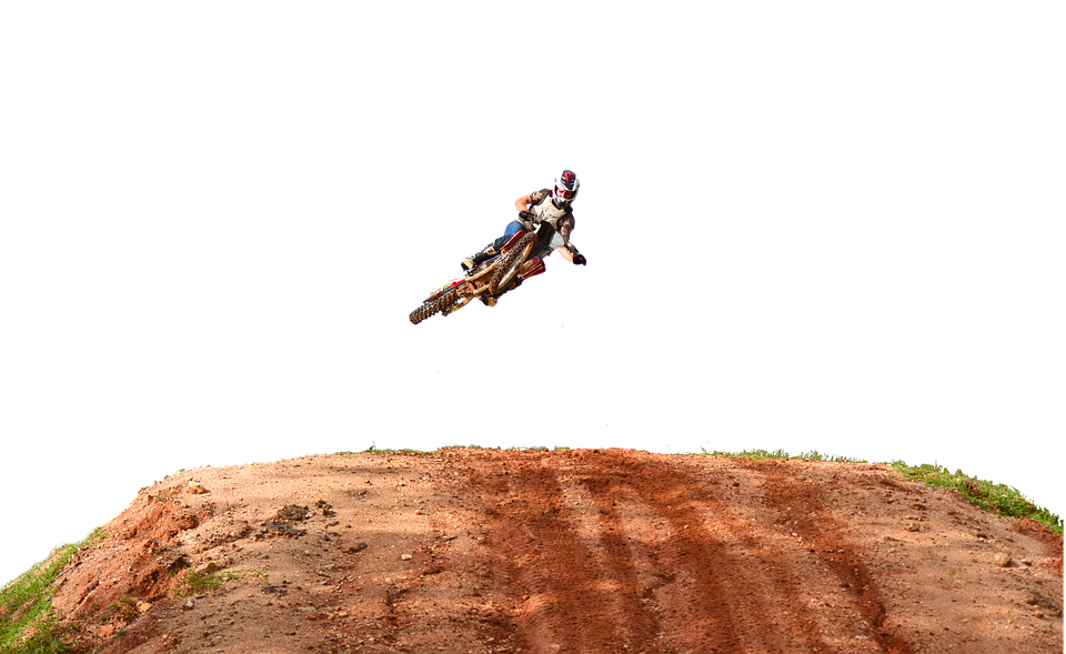 A Person On A Dirt Bike Jumping Over A Dirt Hill