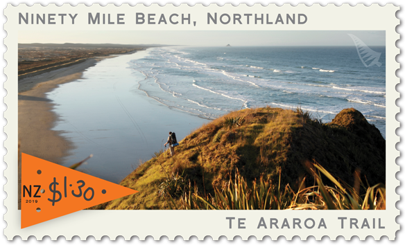 A Stamp With A Person On A Hill Overlooking A Body Of Water