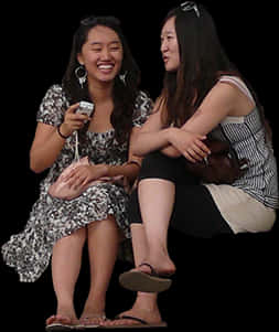 Two Women Sitting On The Ground