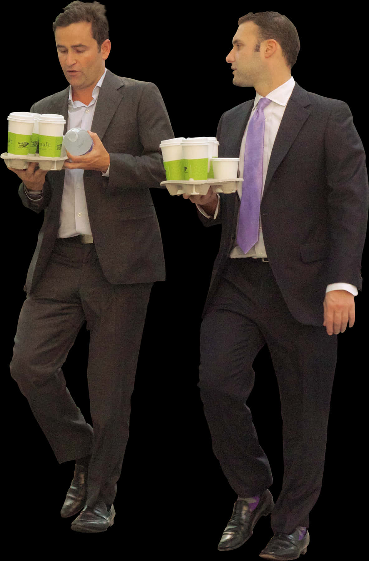 A Couple Of Men In Suits Carrying Coffee Cups