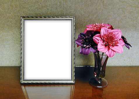 A Picture Frame And Flowers In A Vase