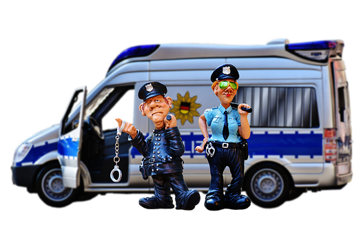 A Toy Police Officers With Handcuffs And A Van