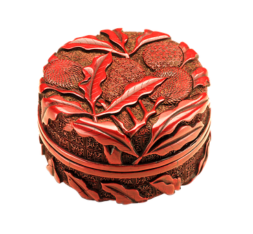 A Red Circular Box With A Carved Design