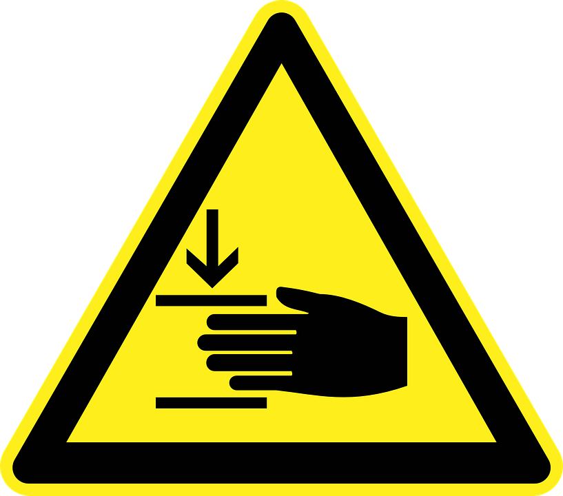 A Yellow Triangle Sign With A Hand Pointing Down