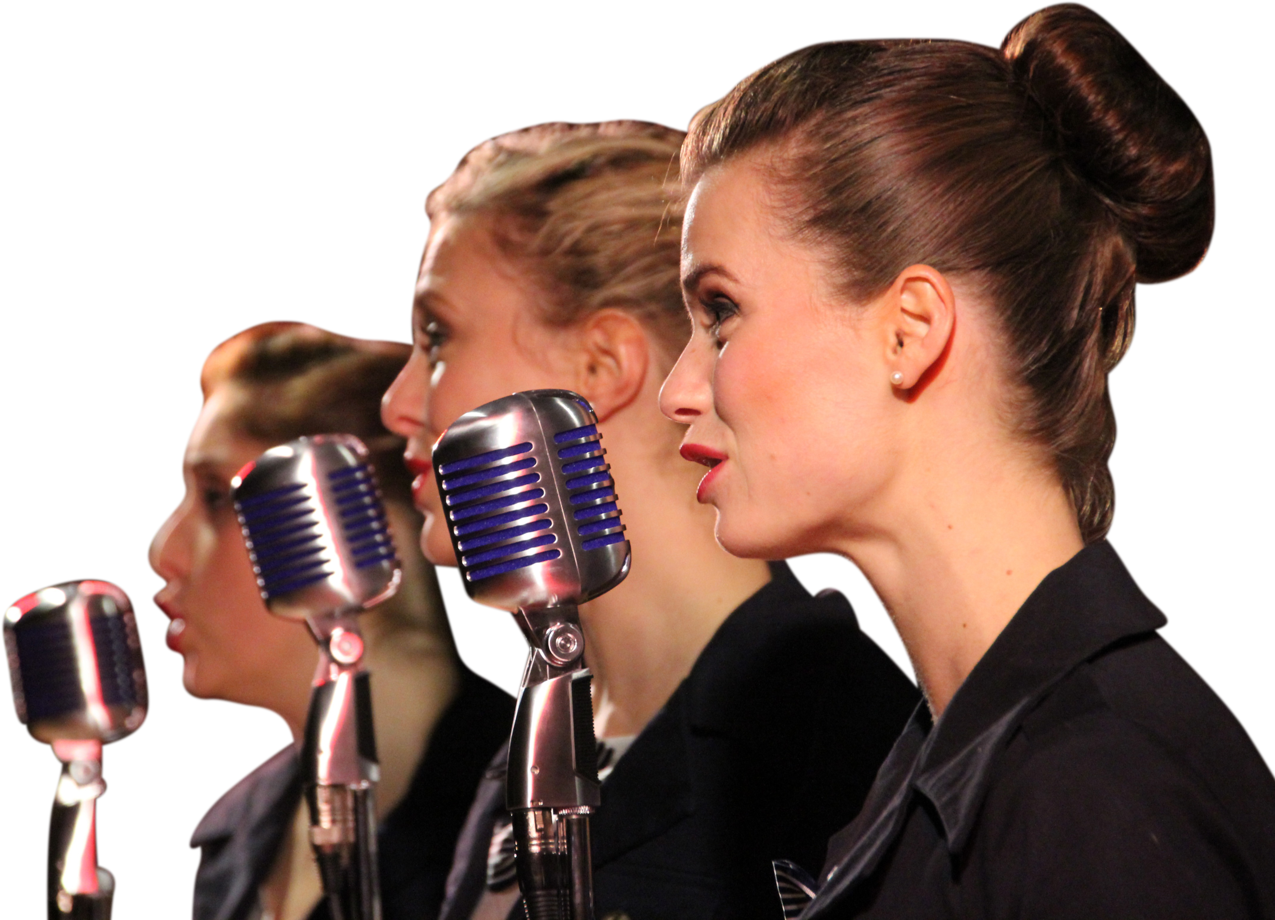 A Group Of Women Singing Into Microphones