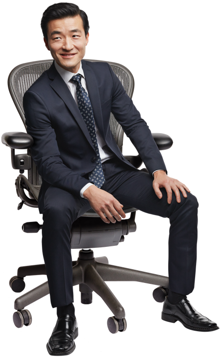 A Man In A Suit Sitting In A Chair
