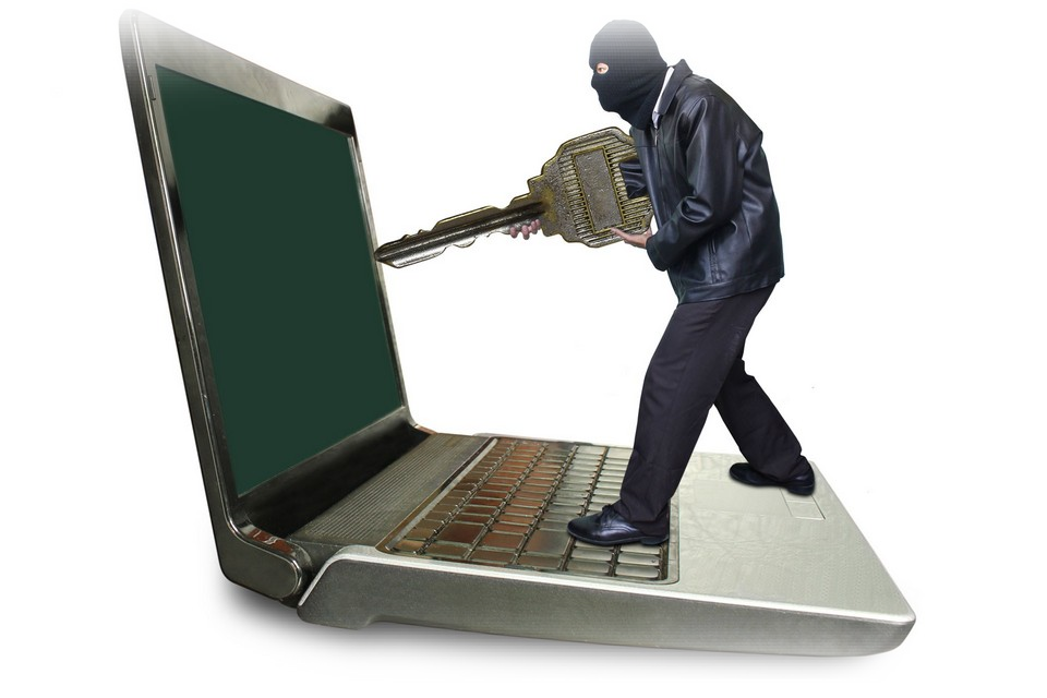 A Man Wearing A Mask Holding A Key To A Laptop